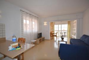 Una sala de estar con un sofá azul y una mesa. en Dharma Home, en Costa Calma