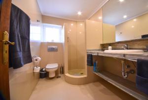 Un baño con lavabo, inodoro y ducha. en Dharma Home, en Costa Calma 26 fotos más