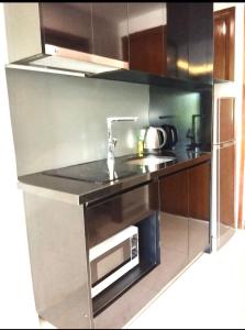 a kitchen with a sink and a microwave at Club Royal Apartments in Pattaya North