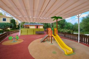 a play area with a playground with a slide at Grupotel Playa Club in Son Xoriguer