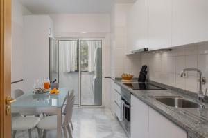 Una cocina blanca con un fregadero y una mesa. en Arcadas III by An Island Apart, en Funchal