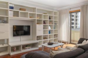 Una sala de estar con estantes blancos y un televisor. en Arcadas III by An Island Apart, en Funchal