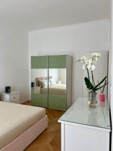 ein Schlafzimmer mit einem Bett und einer Blumenvase auf einem Tisch in der Unterkunft Casa Vicina INALPI ARENA in Turin + 14 Fotos