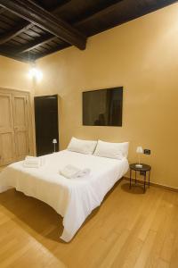 une chambre avec un grand lit blanc dans une pièce dans l'établissement Borgolungo Apartament Viterbo, à Viterbe