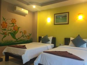 Postel nebo postele na pokoji v ubytování Baan Suan Ta Hotel