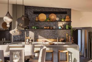 cocina con encimera con sillas y mesa en Shambala Dana - Balinese Inspired Villa with Pool, en Blairgowrie