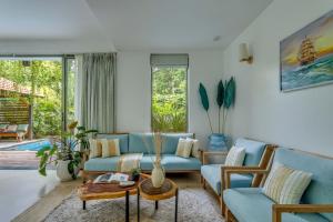 ein Wohnzimmer mit blauen Möbeln und einem Pool in der Unterkunft Casa Maxima - Luxury 4bhk villa with pool in Goa