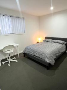 a bedroom with a bed and a desk and a chair at Queen Room in Peaceful and Modern House - OR8 in Guildford