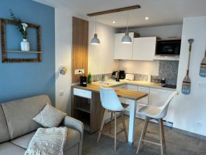 eine Küche mit Tisch und Stühlen und einer Couch in der Unterkunft La Bulle Marine in La Grande-Motte