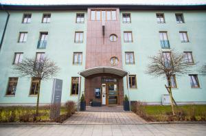 a large building with a door in front of it at Hotel Perlach Allee by Blattl in Munich +68 photos