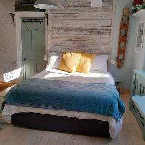 CalstockにあるStudio - Sleeps2 - Parking - Private Courtyardのベッドルーム1室(大型ベッド1台、黄色い枕付)