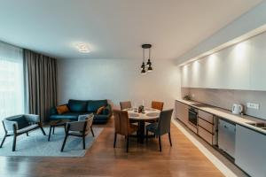 a kitchen and a living room with a table and chairs at BW Cityline Residences in Belgrade
