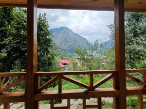Wilderness Cottages and camps kasol في كاسول: اطلالة من نافذة على الجبل