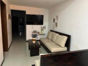 una sala de estar con un sofá y una mesa en 9 Bedrooms house, en Medellín