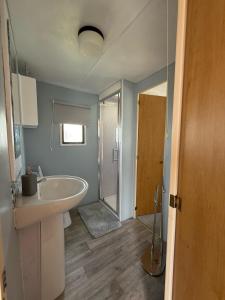 a bathroom with a tub and a sink and a shower at Caravan in Banff