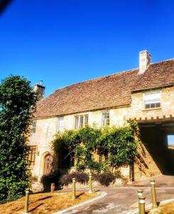 an old stone house with a road in front of it at Cozy Cotswold getaway near Burford in Shilton