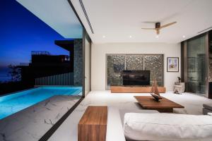 a living room with a tv and a pool at Sea Theatre Kata by ROI in Ban Nong Chaeng