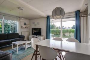 ein Esszimmer und ein Wohnzimmer mit Tisch und Stühlen in der Unterkunft Vakantiehuis De Strandloper - Julianadorp aan Zee in Julianadorp