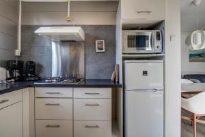 eine Küche mit einem weißen Kühlschrank und einer Mikrowelle in der Unterkunft Vakantiehuis De Strandloper - Julianadorp aan Zee in Julianadorp
