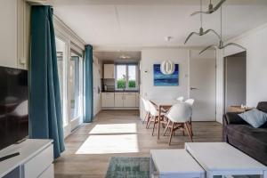ein Wohnzimmer und eine Küche mit einem Tisch und Stühlen in der Unterkunft Vakantiehuis De Strandloper - Julianadorp aan Zee in Julianadorp