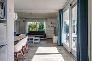 ein Wohnzimmer mit Tisch und Couch in der Unterkunft Vakantiehuis De Strandloper - Julianadorp aan Zee in Julianadorp + 32 Fotos