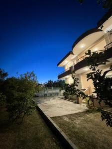 a large white building with a driveway at night at Luna Stay in Vlorë