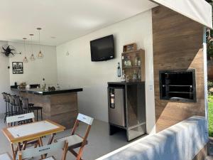 cocina con barra y TV en la pared en Recanto Dubom, a 10 minutos do autódromo Goiânia, en Bela Vista de Goiás