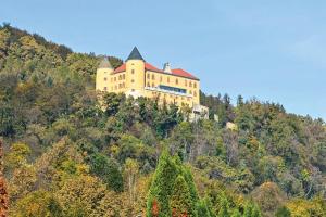 a large yellow building on top of a hill at F95 AQUALUNA KAMP NATURA PODČETRTEK swimming card not included in Podčetrtek