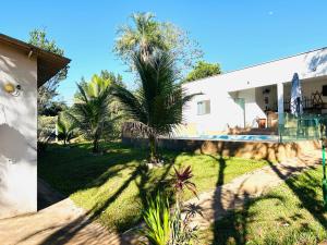 una casa con un patio con palmeras delante en Recanto Dubom, a 10 minutos do autódromo Goiânia, en Bela Vista de Goiás