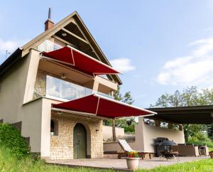 a house with a patio with a red umbrella at KICIKLA Fire & Wine in Nagybakónak