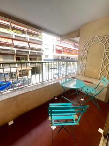 a balcony with a table and chairs in front of a window at Le Cyrille in Antibes