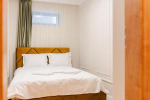 a bedroom with a white bed with a wooden headboard at Stylish Stay - Workspace & Netflix Included in Cluj-Napoca