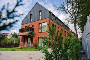 a red brick house with a black roof at Stylish Stay - Workspace & Netflix Included in Cluj-Napoca