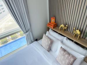 a bedroom with a bed with white pillows and a window at Stylish Studio Apartment with large Balcony and Sea Views, free Parking, Dubai Marina - JBR in Dubai