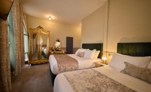 a hotel room with two beds and a mirror at Temple Bar Townhouse in Dublin