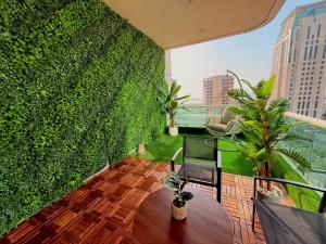 a balcony with a green wall with a chair and plants at Stylish Studio Apartment with large Balcony and Sea Views, free Parking, Dubai Marina - JBR in Dubai +11 photos