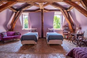 Un dormitorio con dos camas y una pared morada. en Château de la Huberdière, en Nazelles 65 fotos más