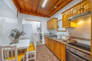 cocina con armarios de madera y encimera blanca en Casita Pedro El Remo, en Los Llanos de Aridane