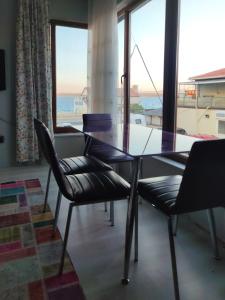 a dining room with a glass table and two chairs at Begonvil Butik Apart in Eceabat +4 photos