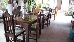 a dining room with a wooden table and chairs at Baan Songjum in Chiang Mai