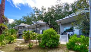 a house with trees and plants in front of it at Krabi Inn Resort in Ao Nam Mao
