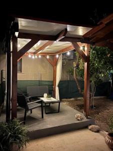 a wooden pergola with a coffee table and a table at Tilemaxos Apartment in Ierissos +14 photos
