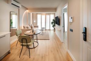 a living room with a table and chairs and a couch at Vita Home Lanzarote I Deluxe Apartments in Arrecife +33 photos