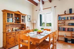 una sala da pranzo con tavolo e sedie in legno di Villa Bini Cinco by Villa Plus a Binibeca