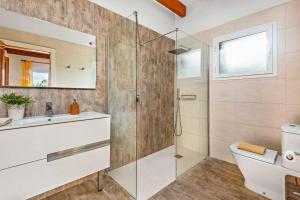 un bagno con doccia in vetro e WC di Villa Bini Cinco by Villa Plus a Binibeca Altre 12 foto