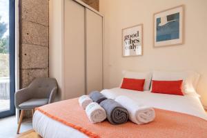 a bedroom with a bed with towels on it at Invictus Escape – Jacuzzi & Charm in the City in Porto