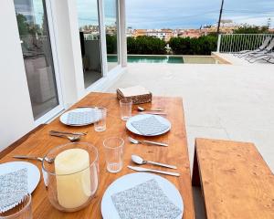 ペニスコラにあるVilla ISLAのバルコニーに置かれた皿とカトラリーが置かれた木製のテーブル