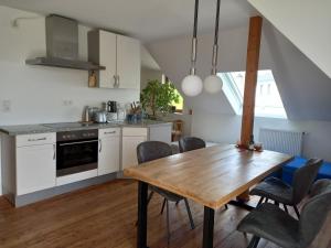 a kitchen with a wooden table and a dining room at Pension Espenhof in Espenscheid