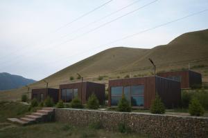 a house in a field with mountains in the background at GlamPark in Kurmenty +7 photos