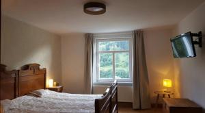 un dormitorio con una cama y una ventana en Elegante Ferienwohnung mit Kaminofen im Thüringer Wald, en Manebach